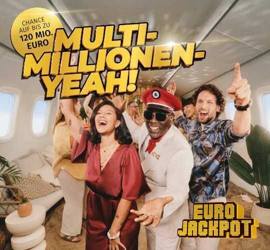 Person steht mit ausgebreiteten Armen auf einem Dach, Blick auf Skyline